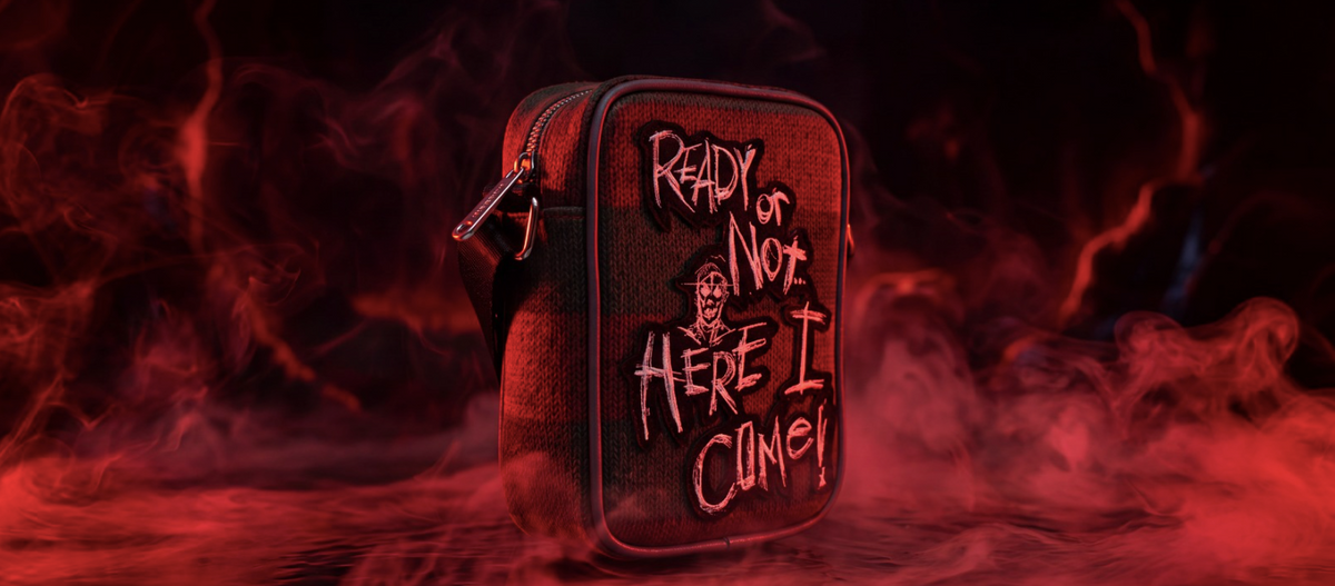 red smokey scenery with a crossbody bag that says "ready or not here i come!" inspired by the movie nightmare on elm st by the brand 'buckle-down'